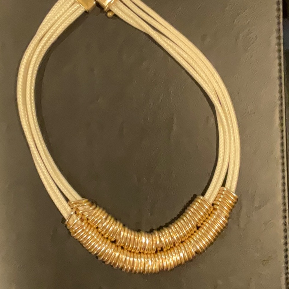 White nylon and gold tone necklace.